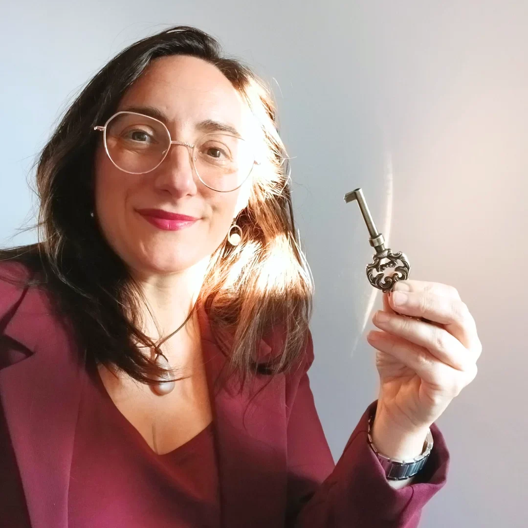 Pour bien diriger une entreprise : la clarté décisionnelle est la clef. Portrait de Magali Warcollier avec une clé, dans la lumière
