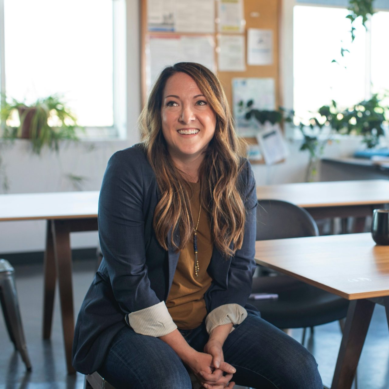 Stress réduit et décision limpide grâce à Clarté5. Femme dirigeante satisfaite et souriante à son bureau.